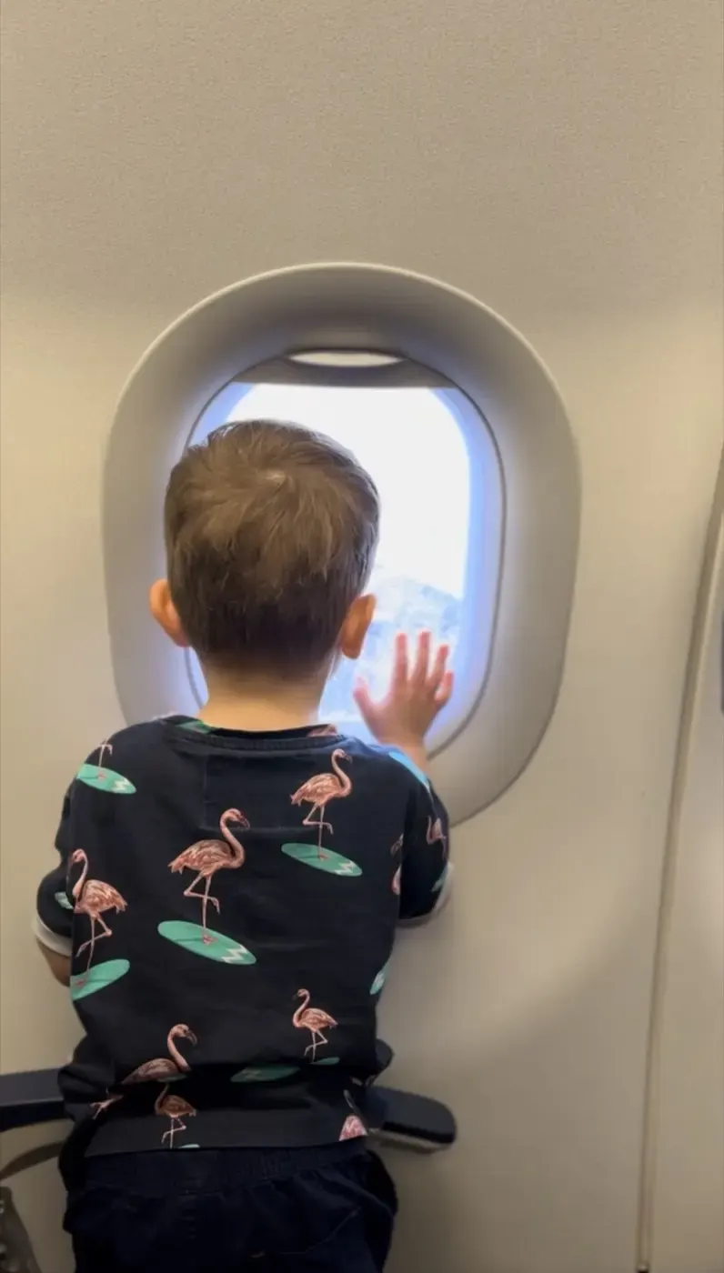 Kleinkind schaut aus dem Flugzeugfenster
